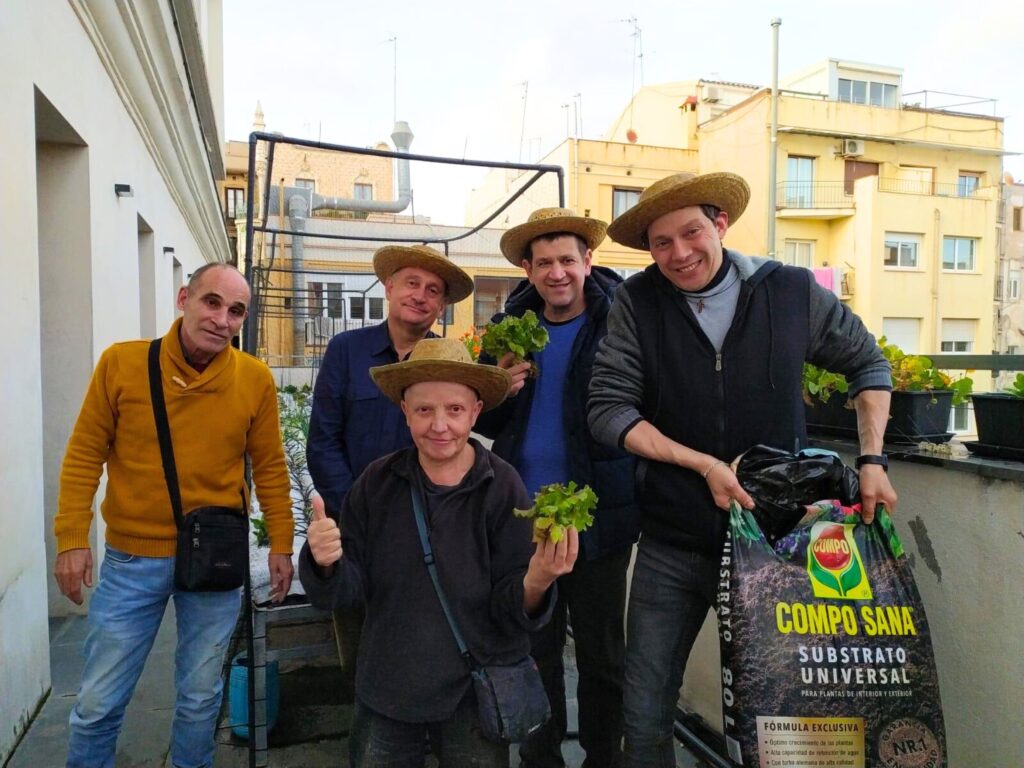 Grup d'homes amb barret mostrant la collita d'enciams 