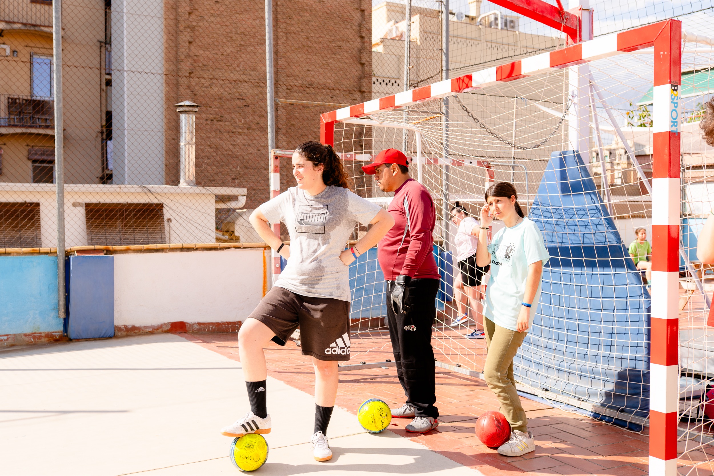 Tres joves davant d'una porteria de futbol